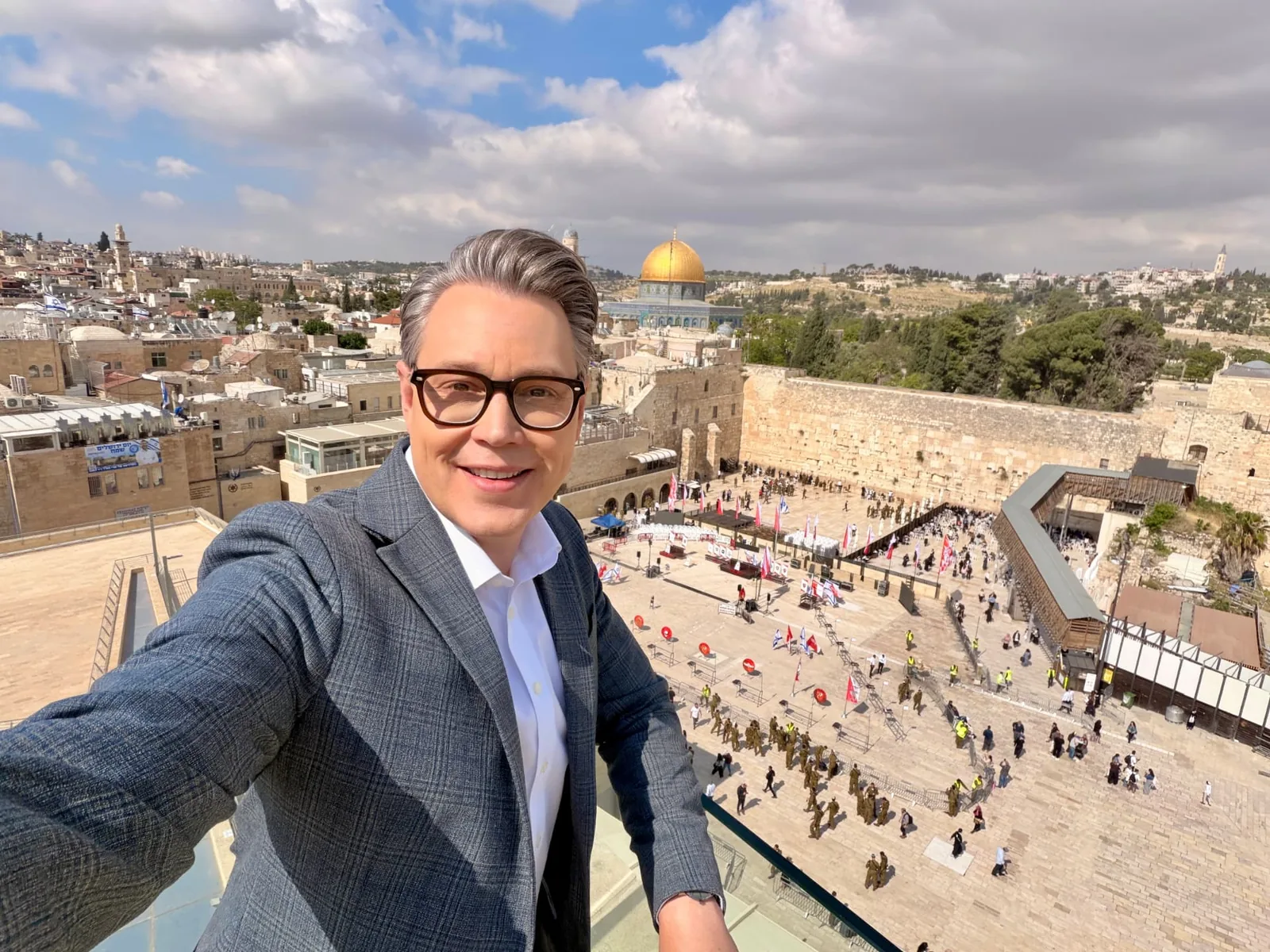 Joshua Swanson at the Western Wall in Jerusalem, with the Dome of the Rock in the distance